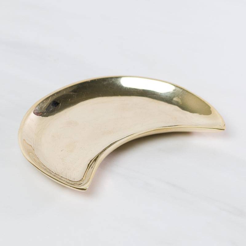 Brass moon-shaped dish from Sacred Light Soundbaths and Crystals, used as a decorative accessories piece.