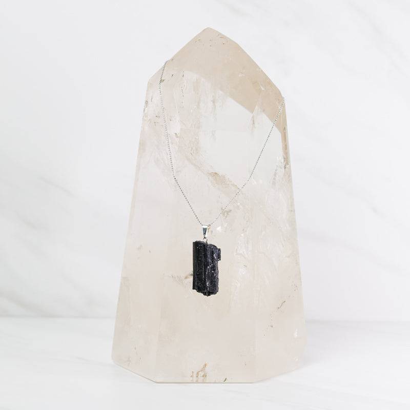 Natural black tourmaline pendant on sterling silver necklace, jewelry piece showcasing polished black stone and silver chain.