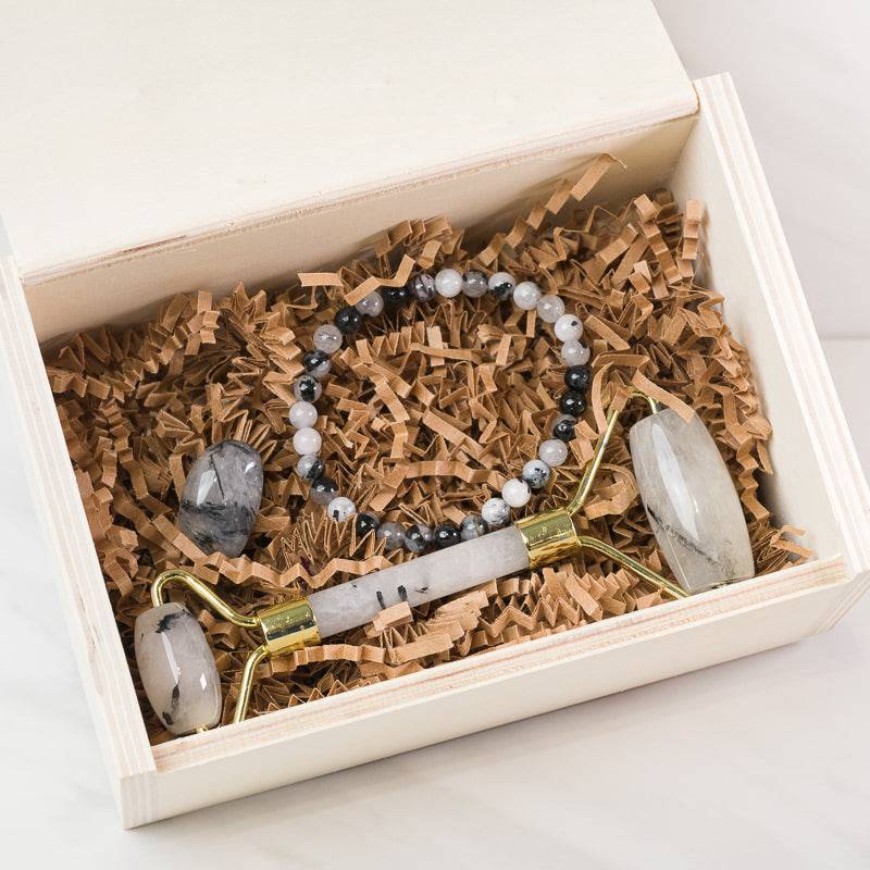 Black Tourmaline in Quartz face massage roller from Sacred Light Soundbaths and Crystals, soothing skincare accessory with stone details.
