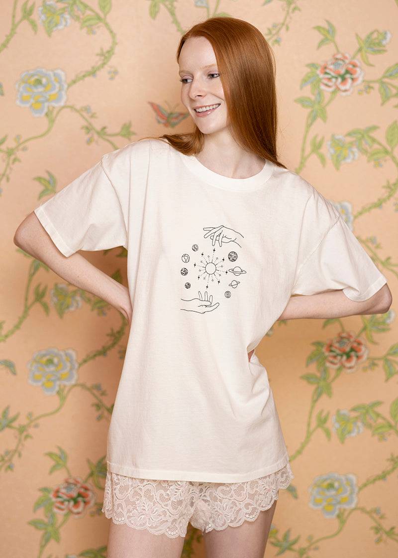Oversized celestial-themed T-shirt from Sacred Light Soundbaths and Crystals featuring star and moon designs on soft fabric.