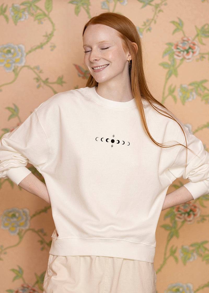 Sacred Light Soundbaths and Crystals moon phases crewneck sweatshirt featuring a graphic of the lunar cycle on soft fabric.