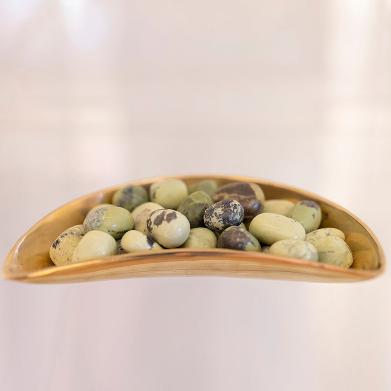 Tumbled serpentine stones with pyrite inclusions, natural mineral crystals from Sacred Light Soundbaths and Crystals.