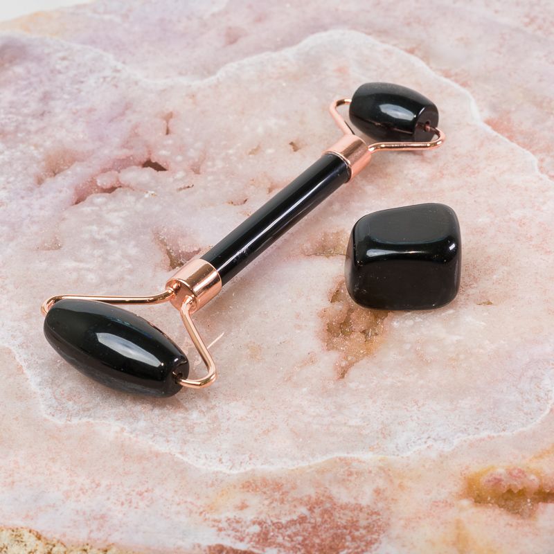 Black Obsidian face massage roller from Sacred Light Soundbaths and Crystals, soothing skincare accessory with smooth rolling surface.