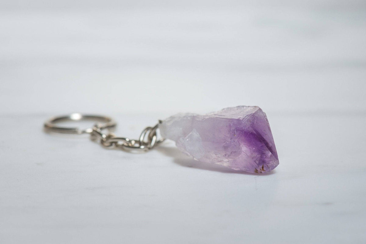 Amethyst keychain from Sacred Light Soundbaths and Crystals, featuring a polished purple crystal pendant on a metal keyring.