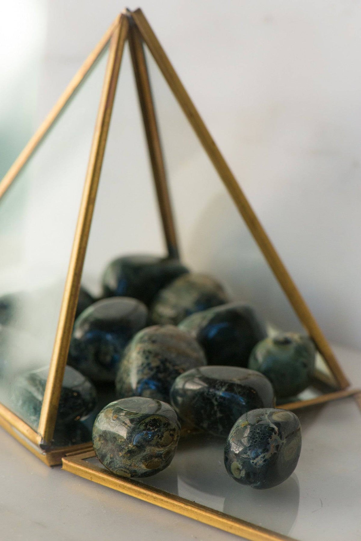 Tumbled Kambaba Jasper stone from Sacred Light Soundbaths and Crystals, showcasing its green and black patterned surface.
