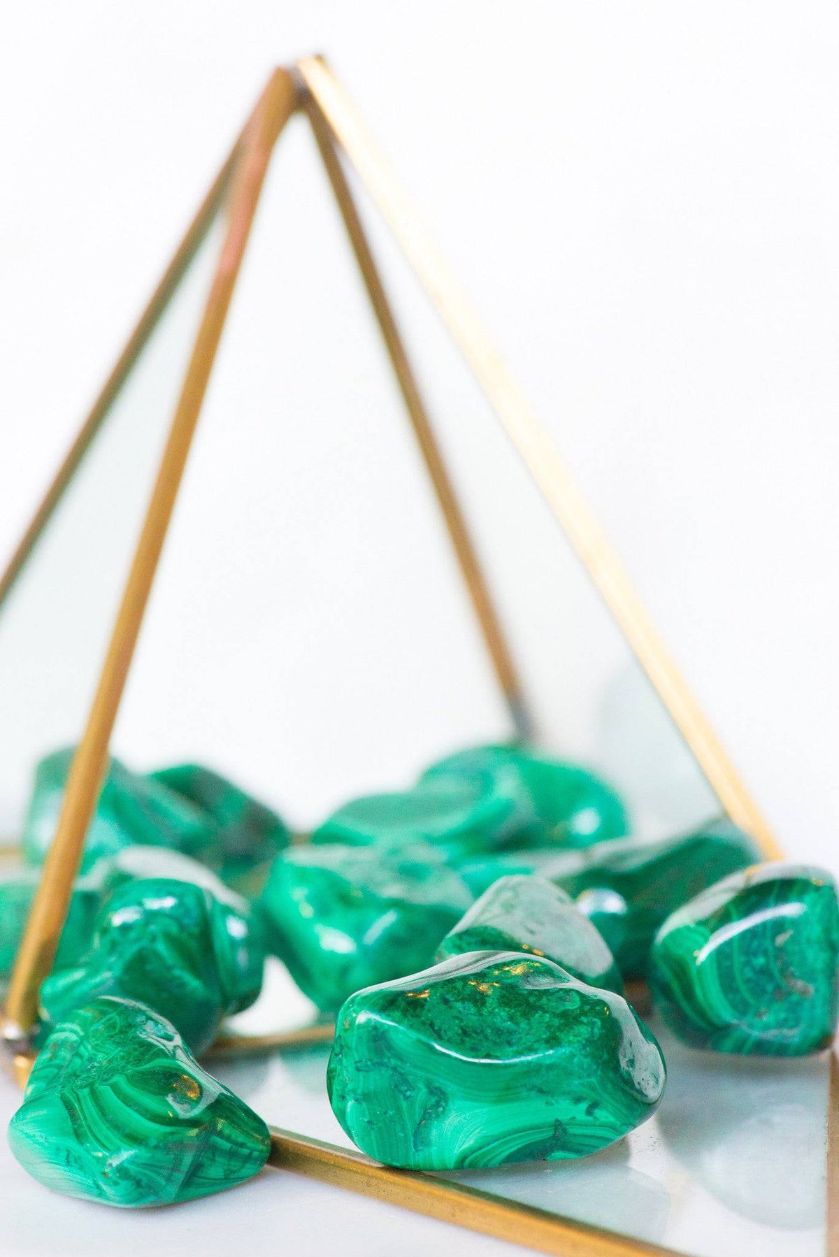 Tumbled malachite stone from Sacred Light Soundbaths and Crystals, showcasing vibrant green and banded patterns.