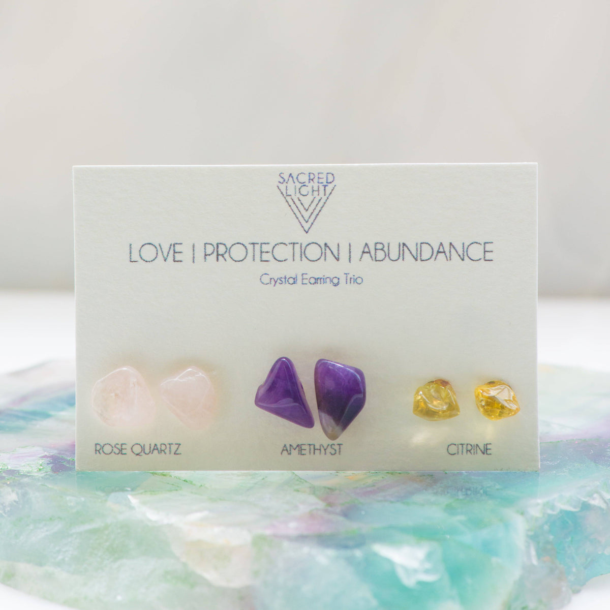 Sacred Light Soundbaths and Crystals Love, Protection, and Abundance Trio Earrings featuring gold-tone hoops with decorative charms.