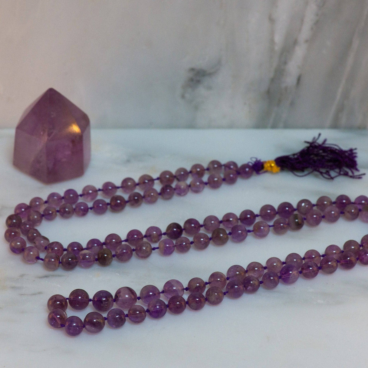 Amethyst mala necklace with 108 beads and silver accents, designed for meditation and spiritual healing.