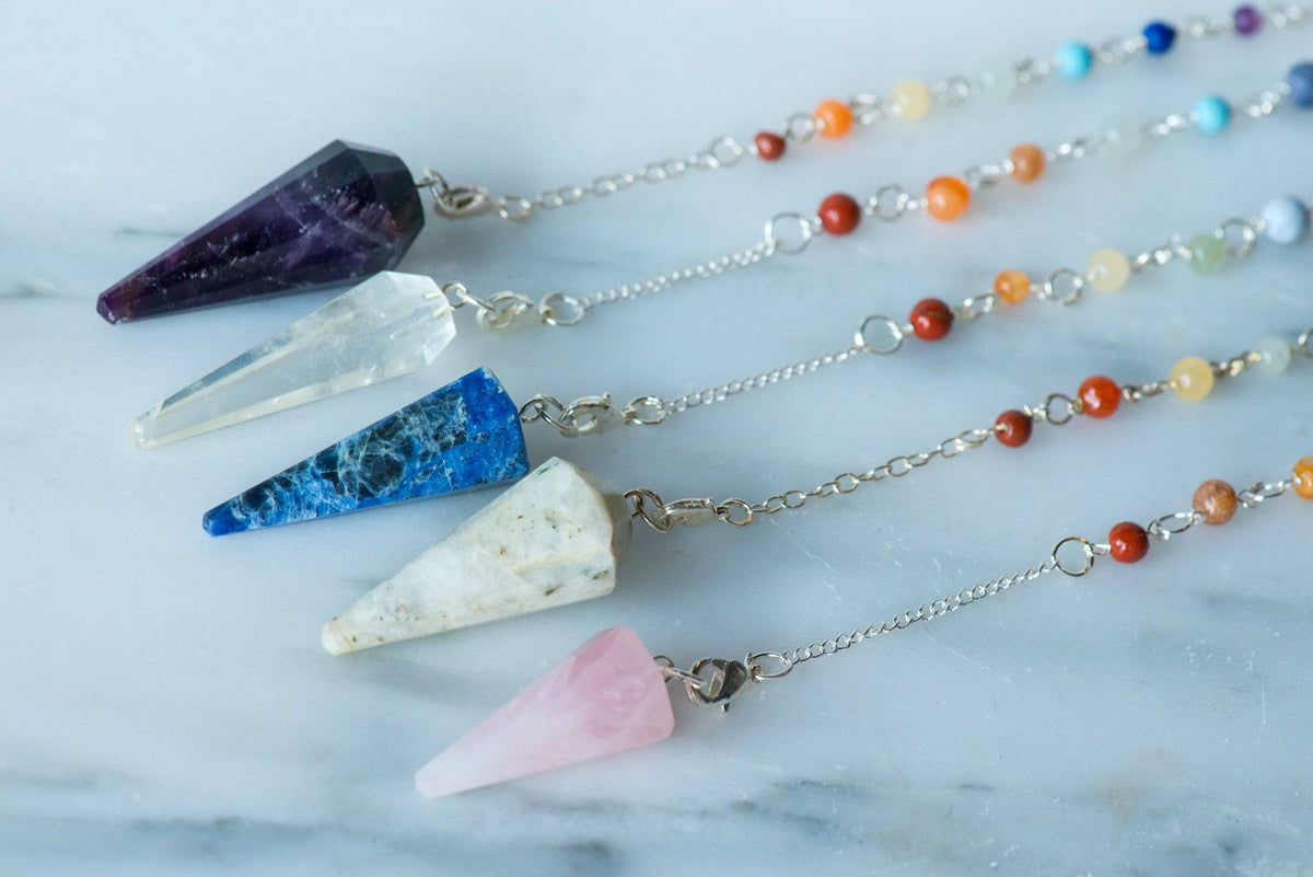 Sacred Light Soundbaths and Crystals chakra pendulum with a polished gemstone and delicate chain for energy balancing.