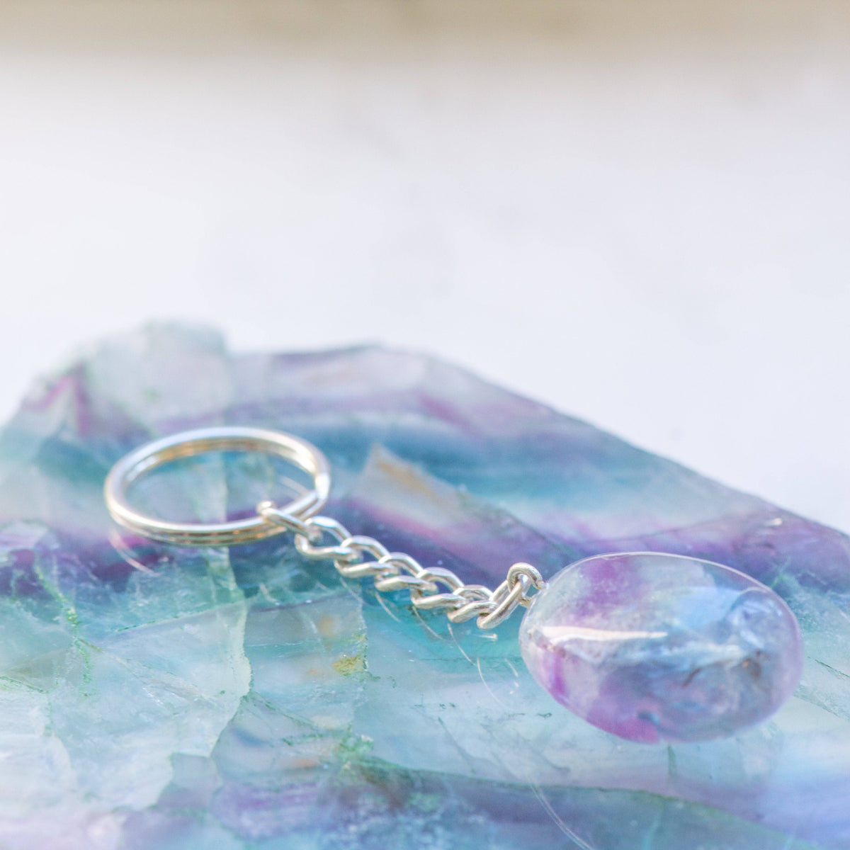Beautiful fluorite stone keychain from Sacred Light Soundbaths and Crystals, showcasing vibrant purple and green mineral hues.