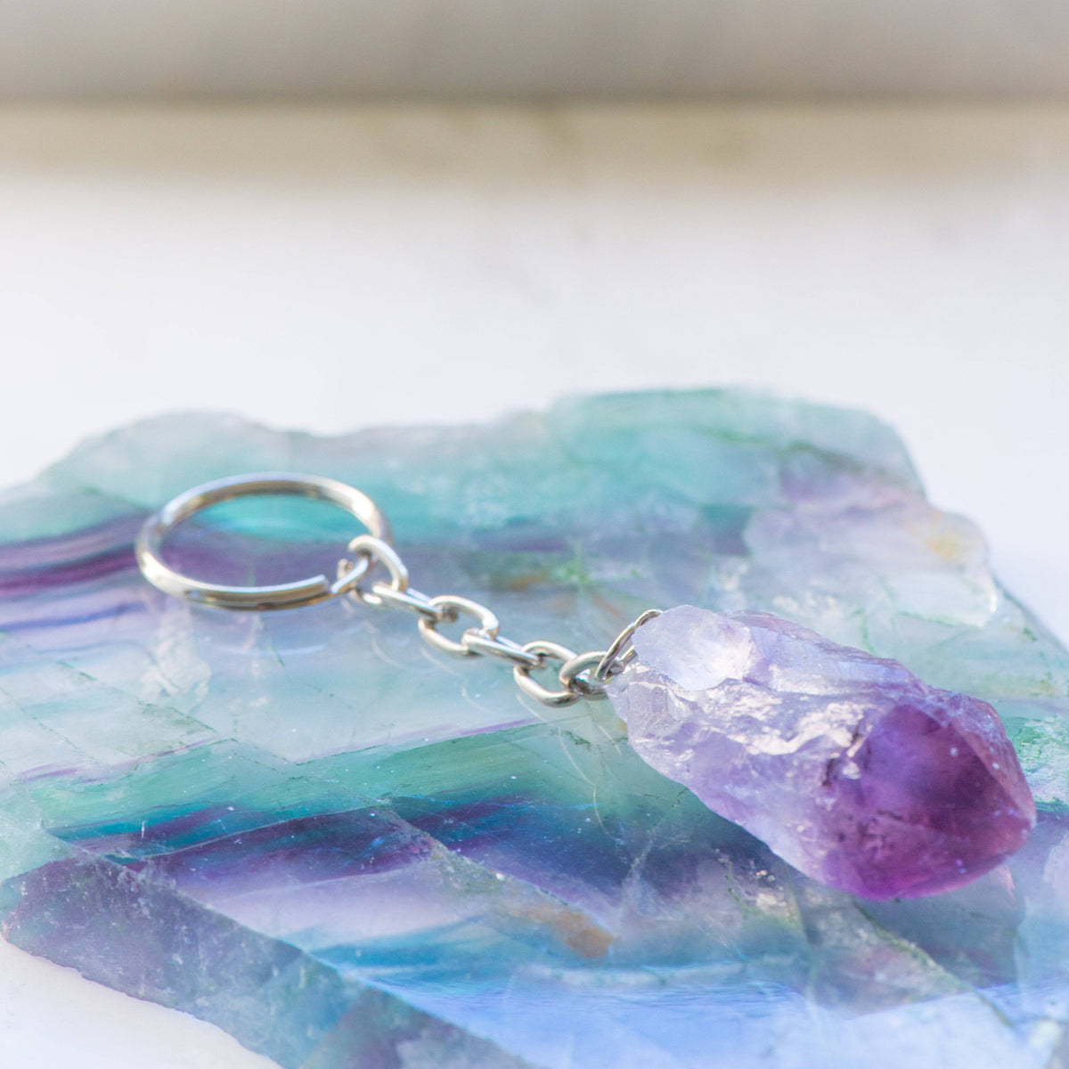Amethyst keychain from Sacred Light Soundbaths and Crystals, featuring a polished purple crystal attached to a metal keyring.
