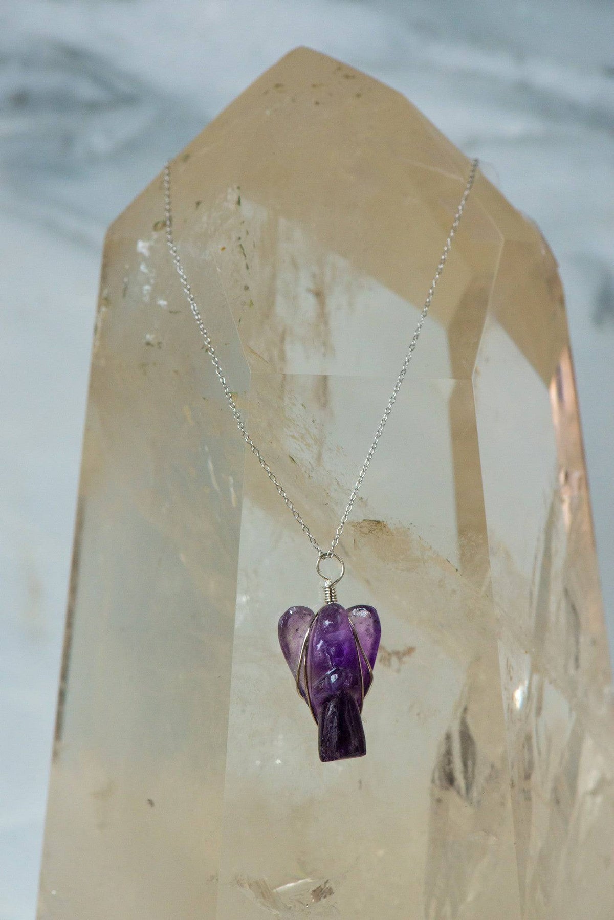 Wire wrapped amethyst angel necklace, handmade jewelry featuring a purple amethyst crystal pendant with intricate wire details.