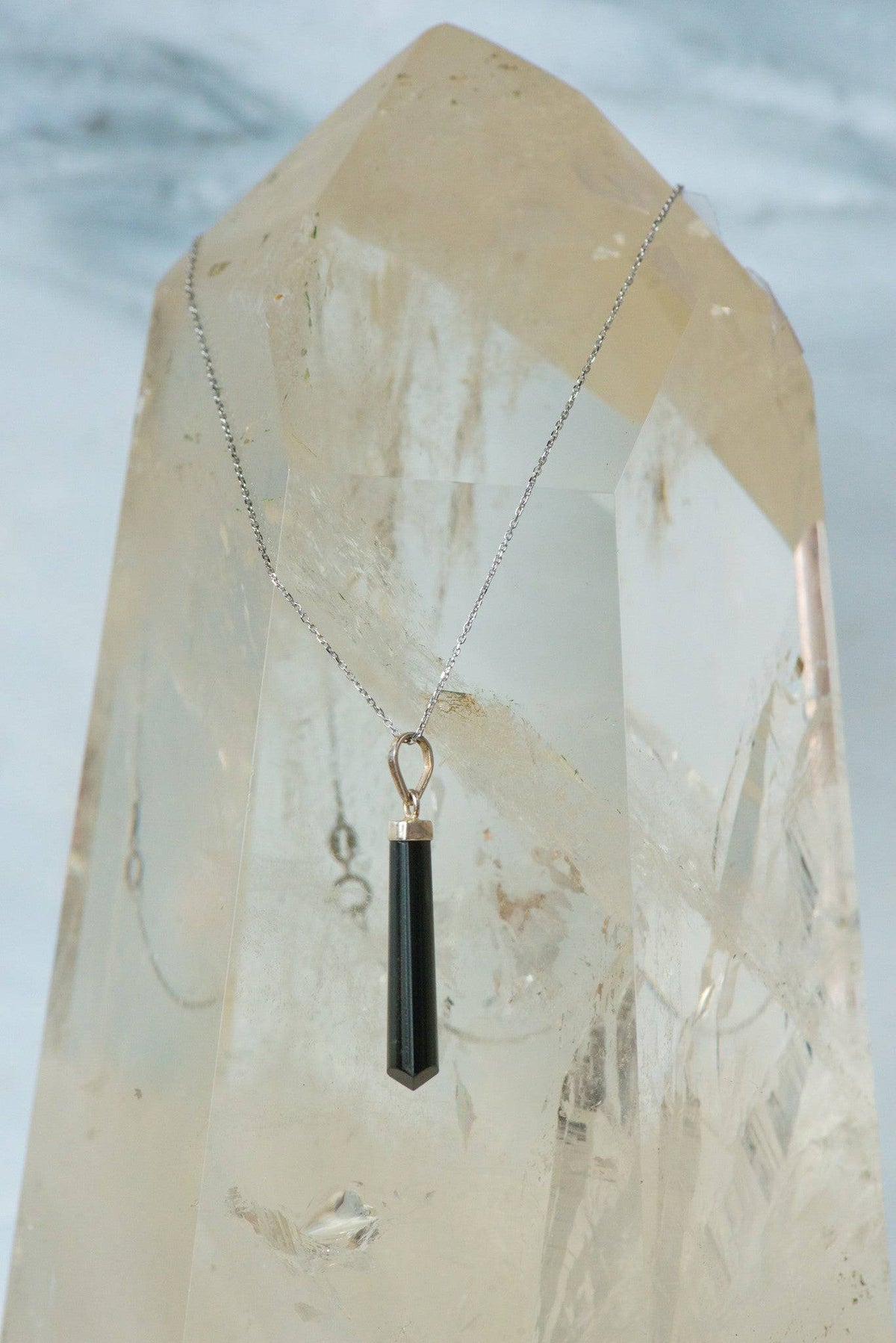 Polished black tourmaline pendant necklace from Sacred Light Soundbaths and Crystals, featuring a sleek, smooth black gemstone jewelry piece.