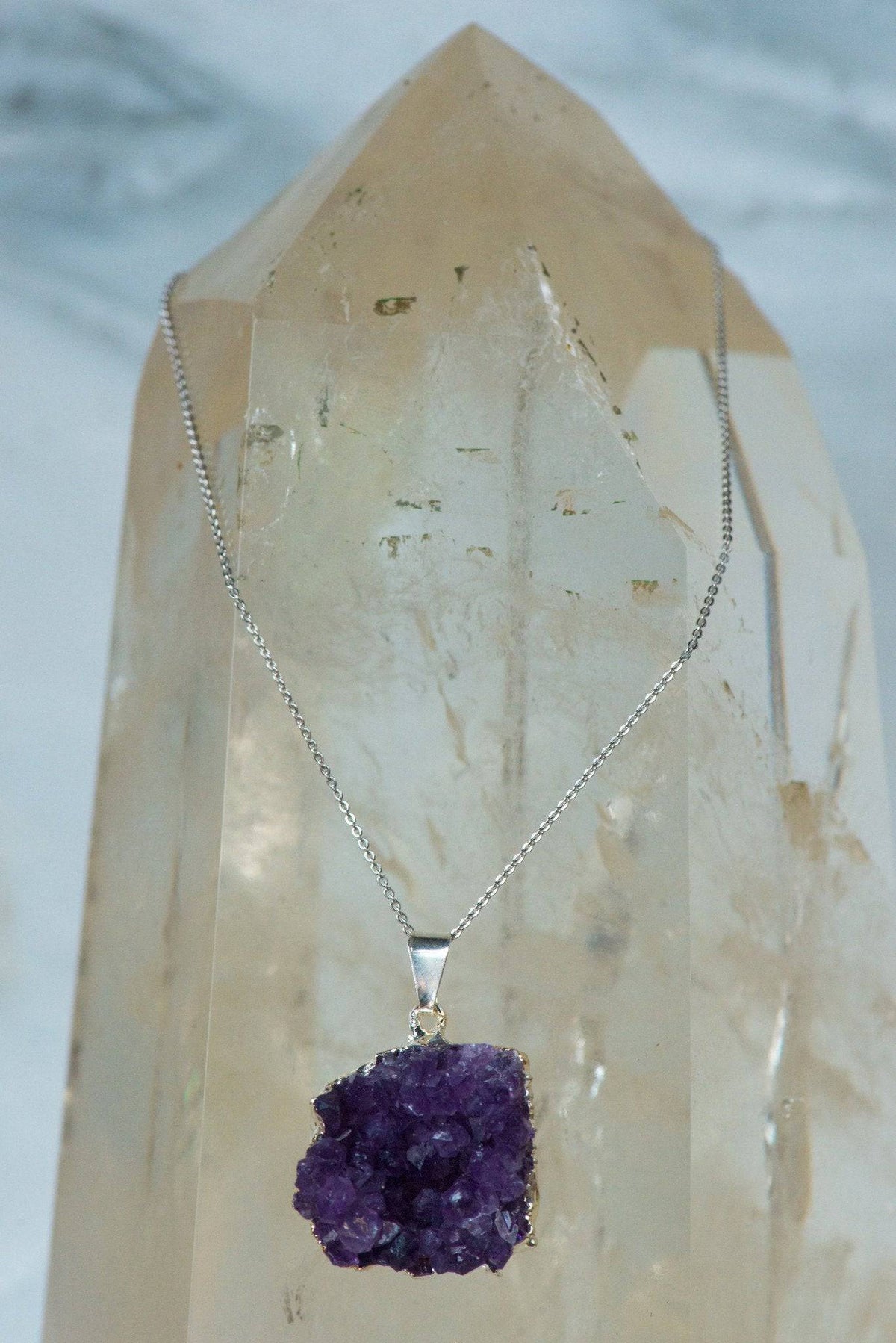 Amethyst cluster pendant on sterling silver chain, showcasing a vibrant purple crystal jewelry piece.