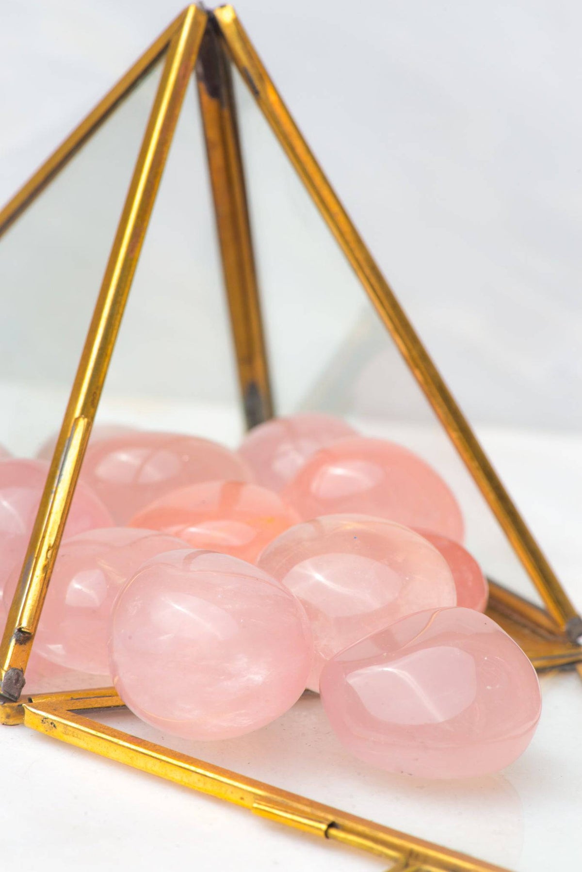 Polished tumbled rose quartz crystal from Sacred Light Soundbaths and Crystals, showcasing its soft pink hue and smooth surface.