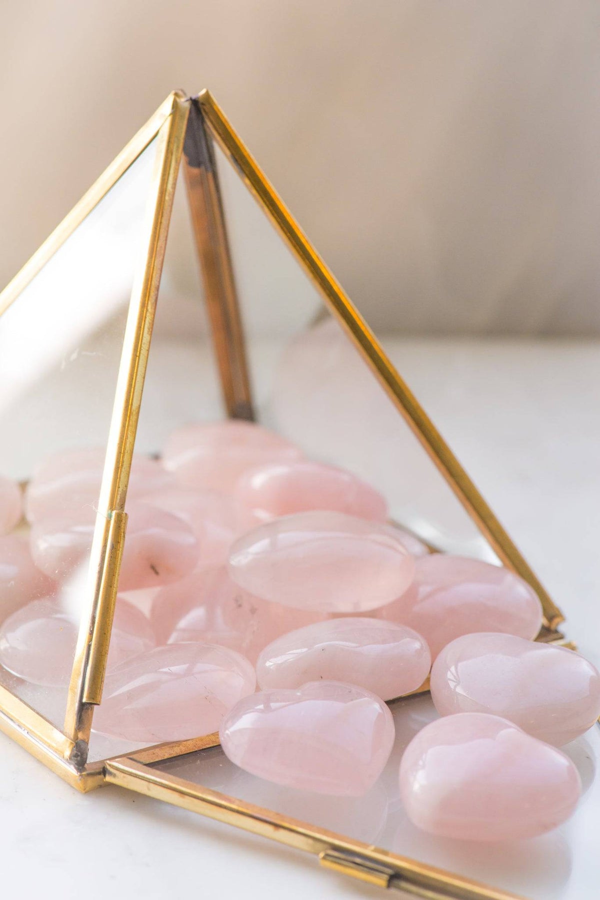 Pink rose quartz heart from Sacred Light Soundbaths and Crystals, smooth polished gemstone with gentle glow and natural crystal texture.