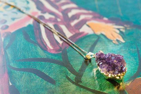 Sterling silver necklace with a natural purple amethyst pendant, showcasing intricate silver detailing and vibrant gemstone.