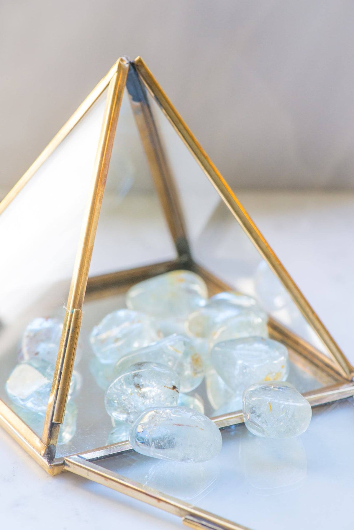 Tumbled blue topaz stone from Sacred Light Soundbaths and Crystals, showcasing a smooth, polished blue gemstone with natural variations.