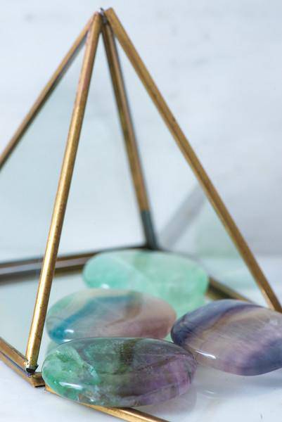 Smooth fluorite palmstone from Sacred Light Soundbaths and Crystals, showcasing vibrant green and purple hues and polished surface.