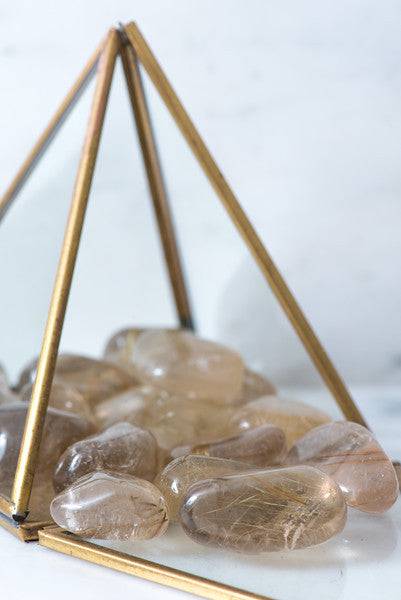 Tumbled Rutilated Quartz crystal from Sacred Light Soundbaths and Crystals, showcasing its golden rutile inclusions and polished surface.