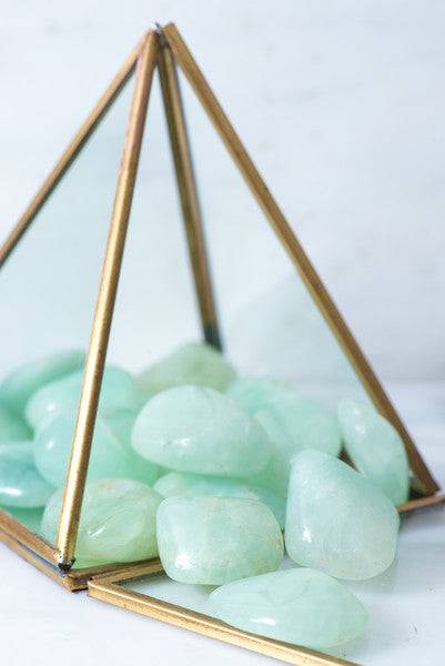 Smooth tumbled Prehnite crystal from Sacred Light Soundbaths and Crystals, showcasing its soft green color and polished surface.