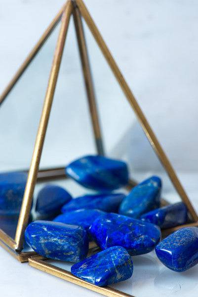 Tumbled lapis lazuli stones from Sacred Light Soundbaths and Crystals, showcasing deep blue with gold flecks and smooth polished surface.