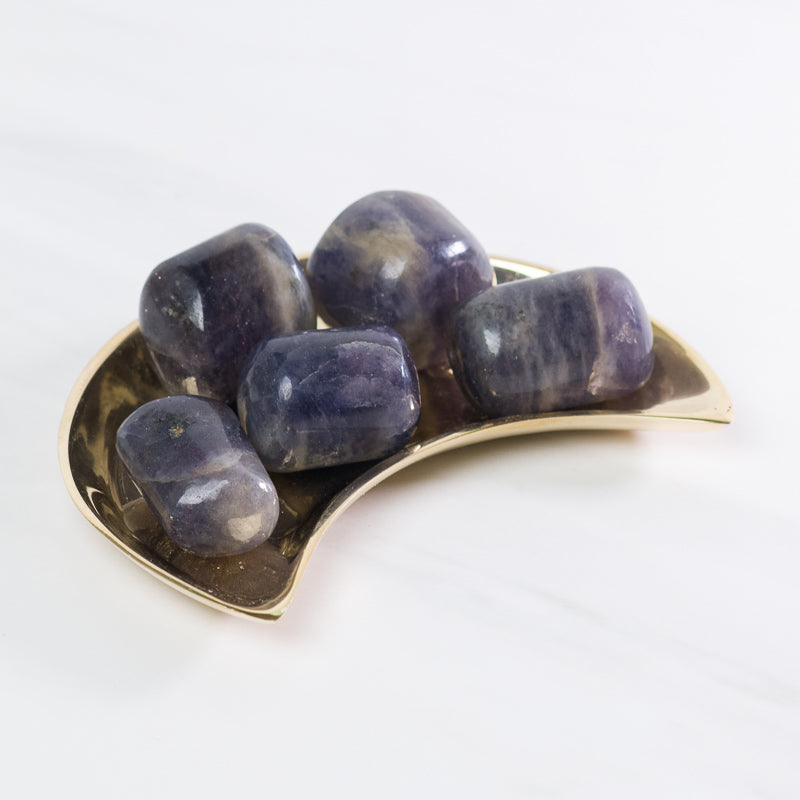 Tumbled Iolite stone from Sacred Light Soundbaths and Crystals, showing smooth, polished purple-blue mineral with natural variations.