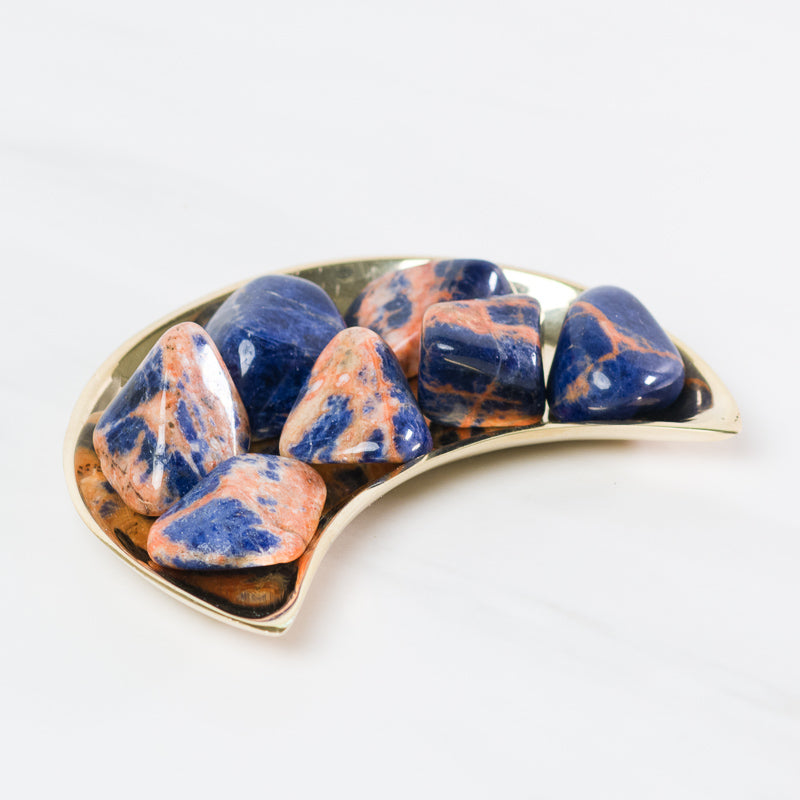 Sunset Sodalite stone from Sacred Light Soundbaths and Crystals, showcasing its deep blue and orange sunset-like color patterns.