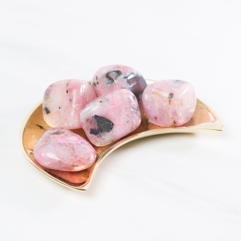 Tumbled pink cobaltian calcite stone from Sacred Light Soundbaths and Crystals, smooth pink and blue mineral with natural polish.