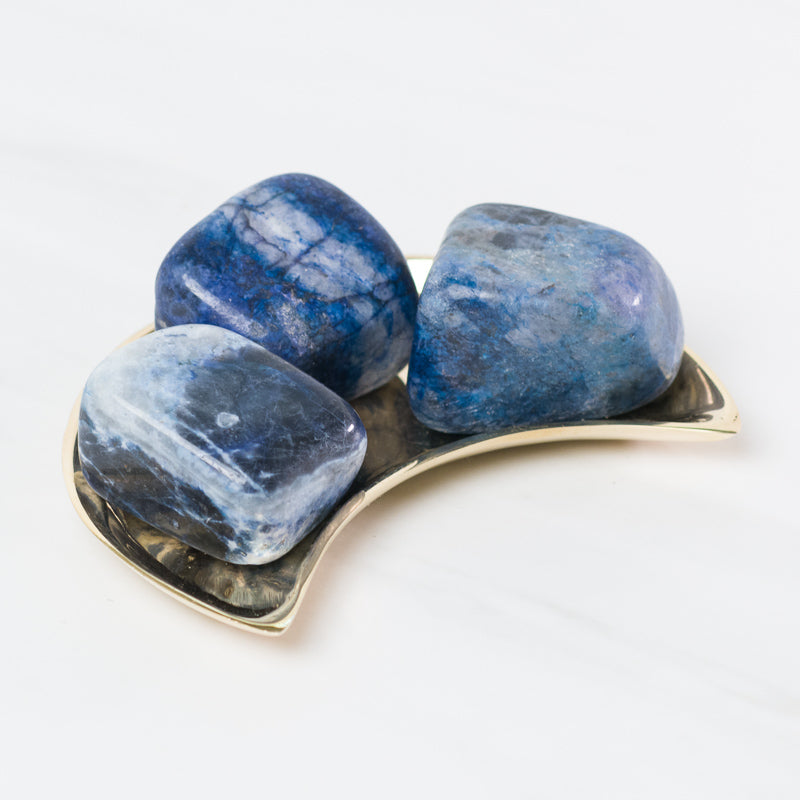 Sodalite stone from Sacred Light Soundbaths and Crystals, showcasing deep blue and white mineral patterns with a polished surface.