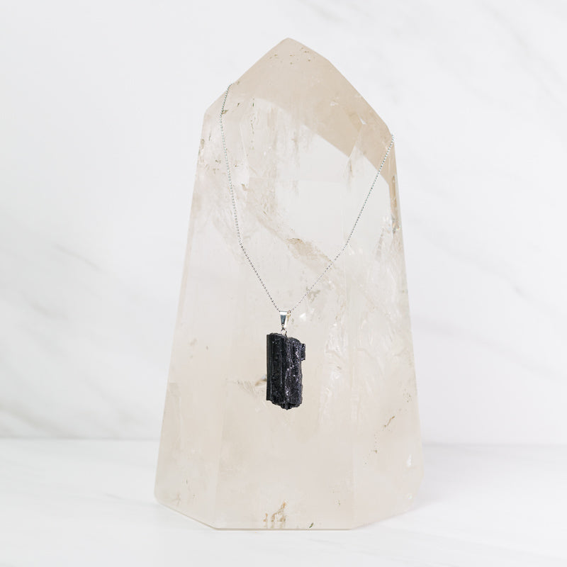 Natural black tourmaline pendant on sterling silver necklace, jewelry piece with a polished black stone and silver chain.