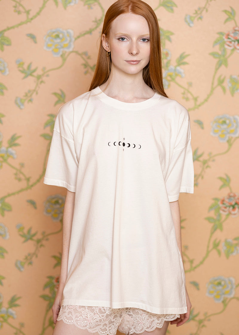Sacred Light Soundbaths and Crystals Moon phases T-shirt featuring a design of the lunar cycle on a black fabric background.