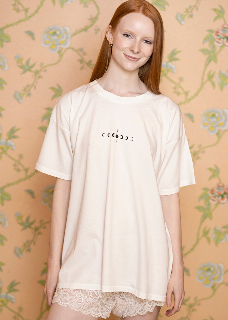Sacred Light Soundbaths and Crystals Phases of the Moon T-Shirt featuring a graphic of the moon's different phases on soft fabric.