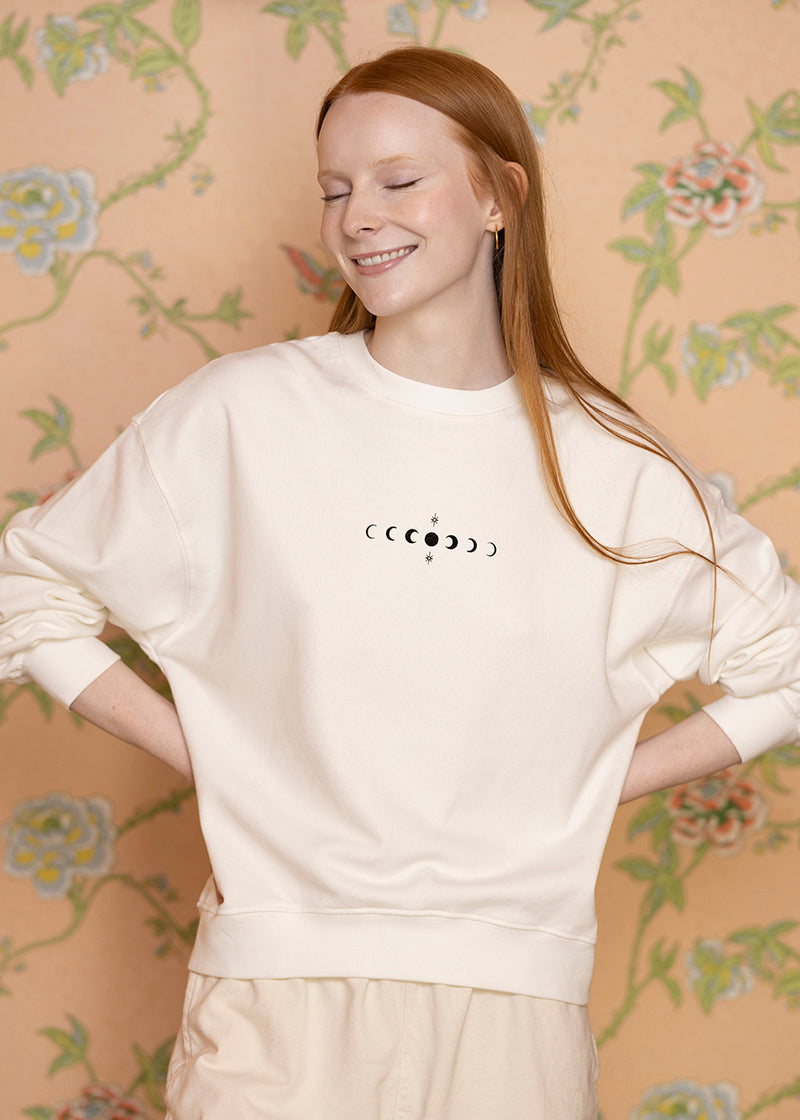 Sacred Light Soundbaths and Crystals moon phases crewneck sweatshirt featuring a detailed print of lunar cycle illustrations.