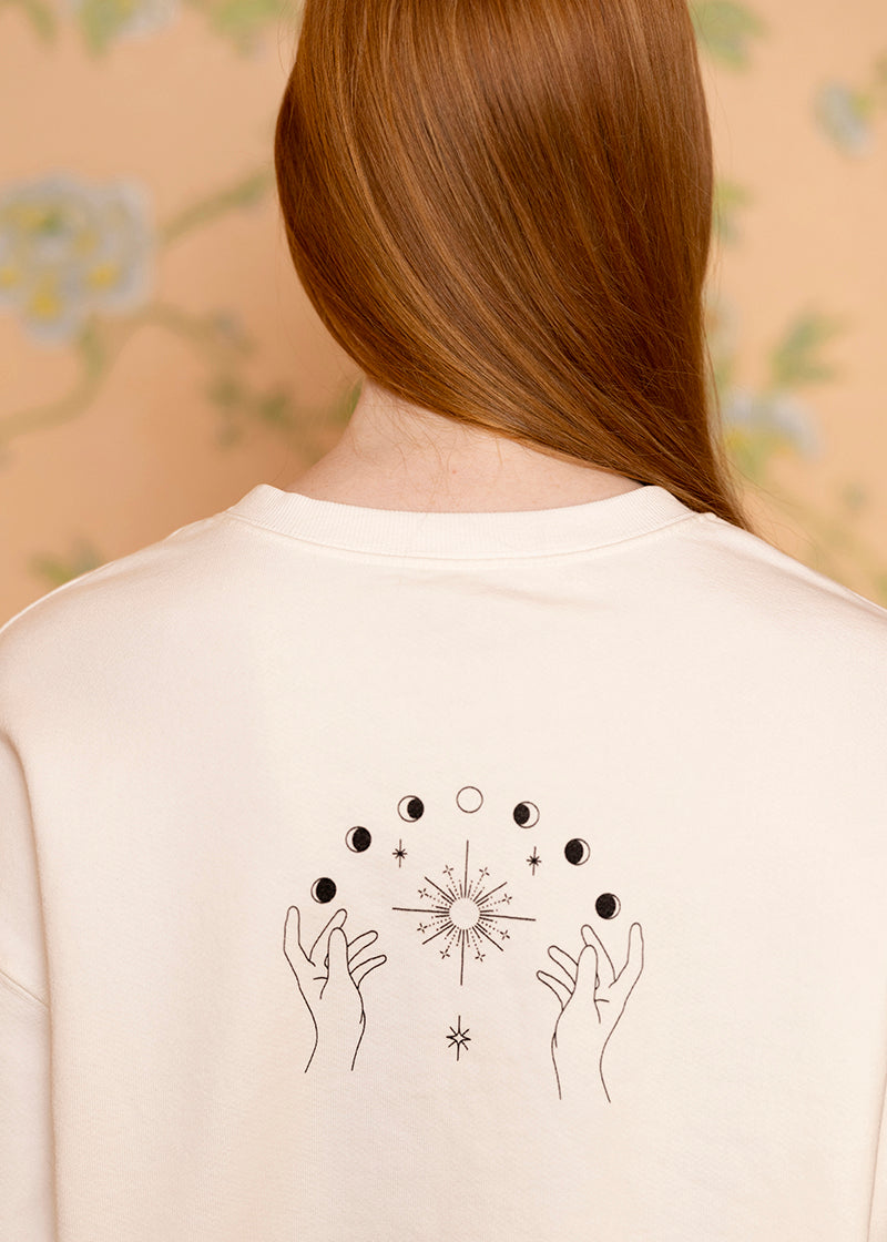 Sacred Light Soundbaths and Crystals moon phases crewneck sweatshirt featuring a celestial moon phase design on soft fabric.