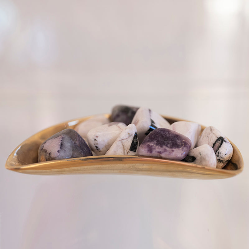 Close-up of tumbled tourmaline, lepidolite, and kunzite stones from Sacred Light Soundbaths and Crystals, showing vibrant colors and smooth textures.