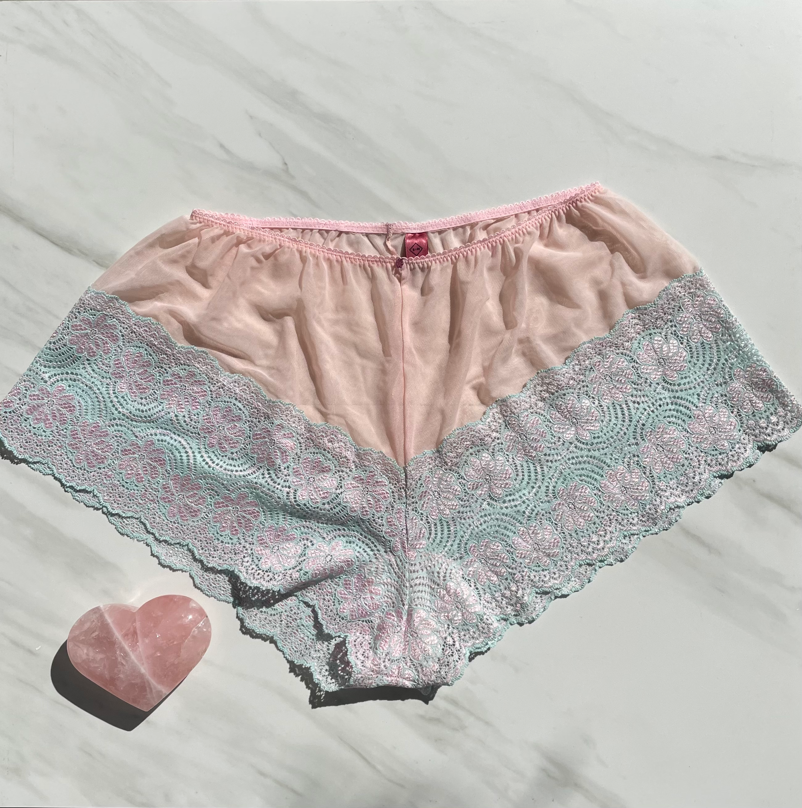 Limited edition pink lace underwear with ruby gem embellishments by Sacred Light, featuring Goddess Alice design and Columbian lace.